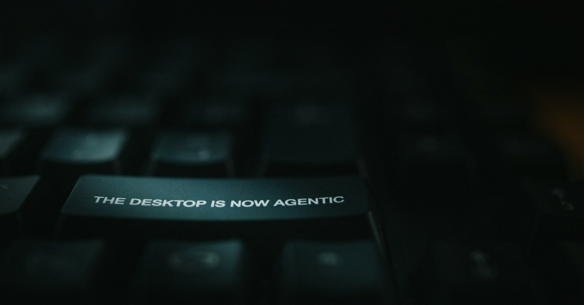 Macro shot of a backlit keyboard key in navy and cyan tones, representing an agentic AI platform reaching the desktop